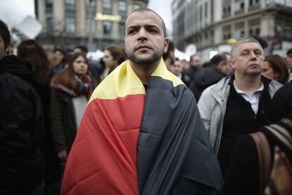 Un hombre cubierto con la bandera belga durante el minuto de silencio celebrado en el centro de Bruselas (Bélgica), el 23 de marzo de 2016.