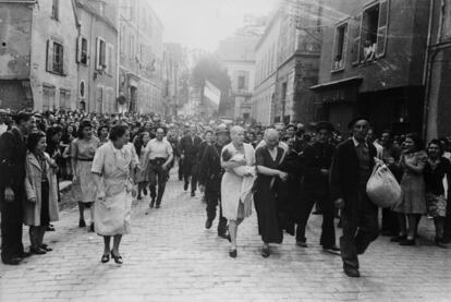 Simone Touseau, con su bebé en brazos por las calles de Chartres (Francia). El padre de su bebé era alemán. A su lado, su madre, también rapada. Recorren las calles de la ciudad siendo humilladas como castigo por ser colaboradoras de las tropas alemanas, en 1944.