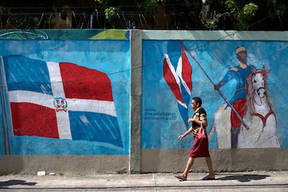 Una mujer camina cerca de un centro de votación en la capital. Este domingo, los dominicanos elegirán al presidente de la República, a su vicepresidenta y a los miembros del Congreso que ocuparán los 32 escaños del Senado y los 190 de la Cámara de Diputados.