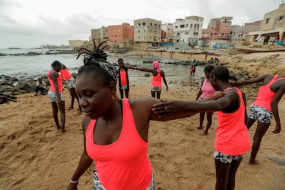 Khadjou Sambe entrena a unas alumnas principiantes como profesora de la escuela Black Girls Surf en la playa de Ngor, en Dakar, Senegal, el 3 de agosto de 2020. Calentamientos antes de meterse en el agua con la tabla.