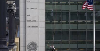 Un hombre limpia los vidrios de la sede de la SEC, la CNMV estadounidense. 