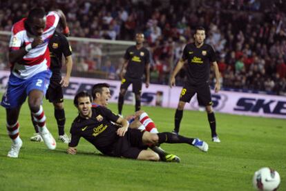 Cesc se queda tendido sobre el césped mientras Nyom persigue el balón durante el partido Granada-Barcelona del martes.