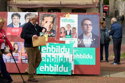 Un hombre pasa delante de un panel en Vitoria con propaganda electoral de diferentes partidos políticos para las próximas elecciones vascas del 21 de abril.