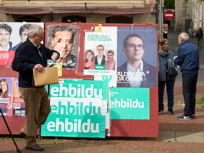 Un hombre pasa delante de un panel en Vitoria con propaganda electoral de diferentes partidos políticos para las próximas elecciones vascas del 21 de abril.