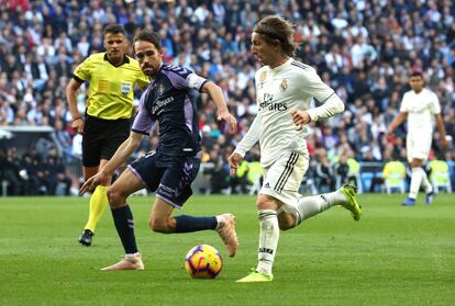 El centrocampista del Valladolid Michel (derecha) presiona a Luka Modric. 