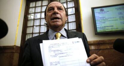 El diputado Martínez-Pujalte muestra un documento para defender su fiscalidad.