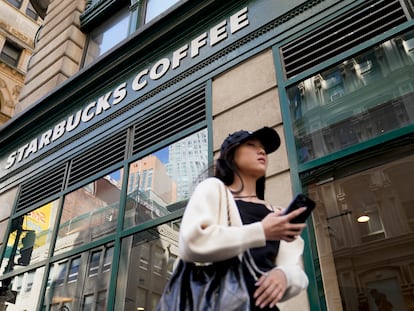 Pedestrians pass a Starbucks in the Financial District of Lower Manhattan on June 13, 2023, in New York.