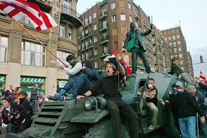 Manifestantes encaramados en el vehículo militar del que se han apoderado durante los incidentes en Budapest, Hungría.