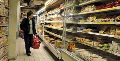 Un cliente observa las estanterías de un supermercado en París.