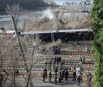 Los bomberos y personal de rescate en la escena de un fatal descarrilamiento de un tren de pasajeros reportado cerca de la estación Spuyten Duyvil en el barrio del Bronx de Nueva York