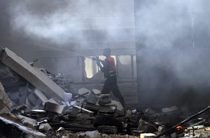 Bomberos palestinos intentan extinguir un incendio en el edificio del Ministerio del Interior de Hamás que ha sido destruido en un ataque aéreo israelí en Gaza