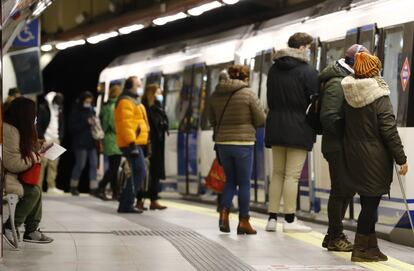 Varias personas esperan para subirse al vagón en una estación del Metro de Madrid.