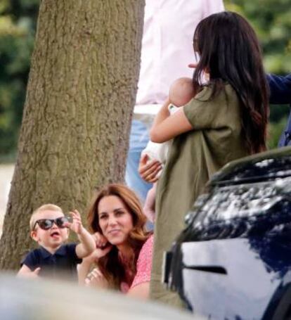 El príncipe Luis bromea mientras es observado por su madre, Kate Middleton, y Meghan Markle que tiene en brazos a Archie.