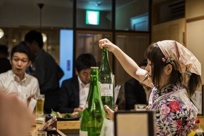 Yuki Chizui ofrece una botella de sake a uno de los comensales. Como el resto, viste el tradicional kimono y busca una estética kawaii, divertida e infantil.