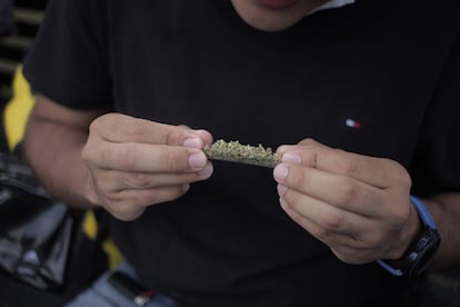 Un hombre se hace un porro de marihuana.