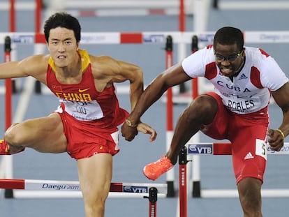 Dayron Robles (a la derecha) agarra a Liu Xiang durante la final de los 110 metros vallas.