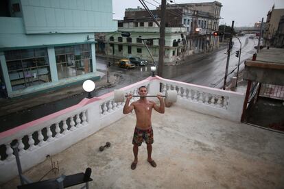 El pintor Dian Peralta hace ejercicios sobre la terraza de su casa en el centro de la Habana, Cuba.