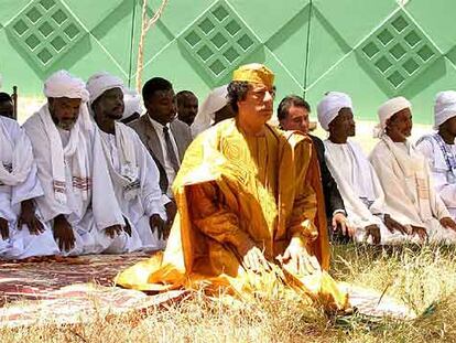 El líder libio, Muammar el Gaddafi, dirige la oración en Trípoli junto a unos dirigentes tribales de Darfur en 2005.