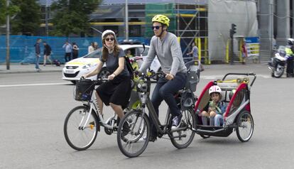 Unos padres en bicicleta con sus hijos pequeños.