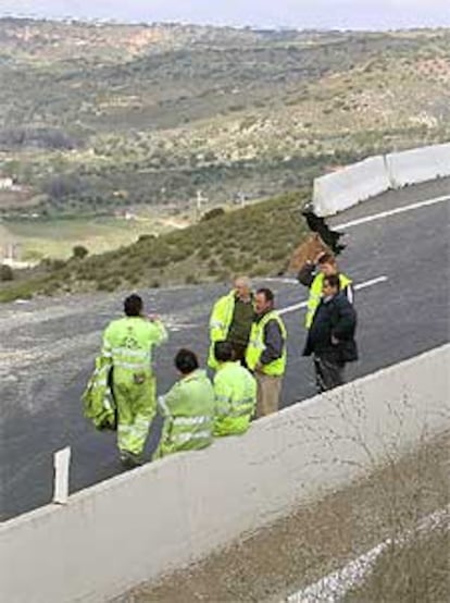 Miembros del Servicio de Mantenimiento de carreteras observan el socavón en la A-3.