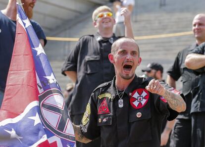 Un integrante del Ku Klux Klan exhibe la bandera en las escaleras del Capitolio.