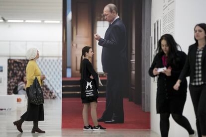 Visitantes pasan junto a una gran foto del presidente ruso, Vladimir Putin, en una exposición fotográfica en Moscú, el 4 de mayo de 2018.