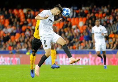 Carlos Soler despeja de cabeza el balón.