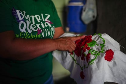 Delmy Cortéz sostiene el bordado hecho por su hija Beatriz previo a su fallecimiento.