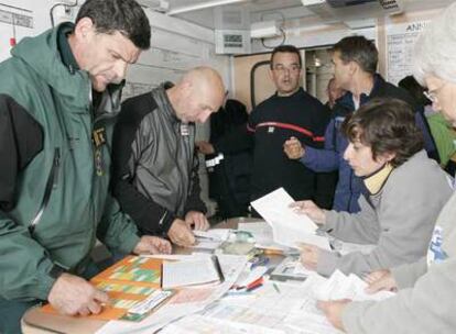 Miembros del equipo de rescate estudian los planos de la sima en la que está atrapada la espeleóloga belga.