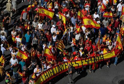 Manifestantes sujetan una bandera de España con le lema "Cataluna es es España".