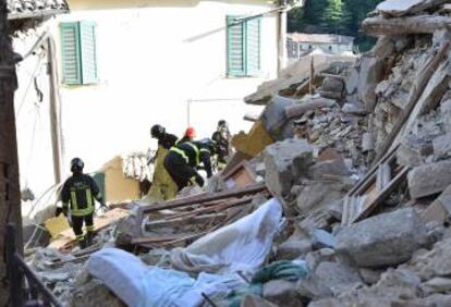 Un equipo de bomberos busca a supervivientes entre los escombros en Arquata del Tronto.