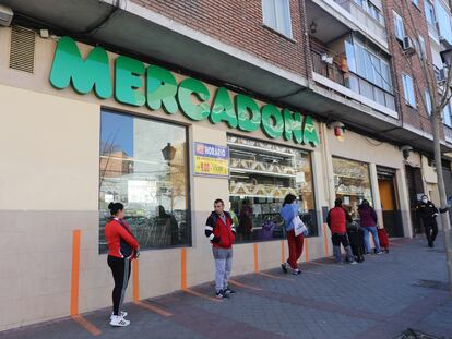 Clientes hacen cola a la entrada de un supermercado respectando la distancia de seguridad.