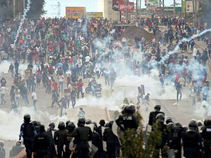 Manifestantes enfrentam a pol&iacute;cia durante protesto enquanto Juan Orlando Hernandez assumia segundo mandato no s&aacute;bado.