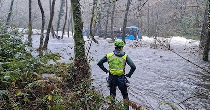 Seis personas han muerto tras la caída de un autobús al río Lérez en el municipio de Cerdedo-Cotobade (Pontevedra), el sábado de Nochebuena. En la imagen, un miembro de los servicios de emergencia observa el vehículo, en el río, este domingo.