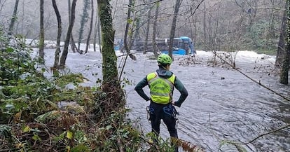 Seis personas han muerto tras la caída de un autobús al río Lérez en el municipio de Cerdedo-Cotobade (Pontevedra), el sábado de Nochebuena. En la imagen, un miembro de los servicios de emergencia observa el vehículo, en el río, este domingo. 