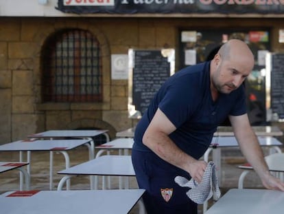 Una persona prepara las mesas para su inminente apertura, en Sevilla.