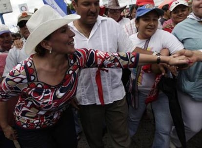 La esposa del mandatario despuesto, Manuel Zelaya, saluda a unos simpatizantes durante una marcha hoy en Tegucigalpa