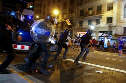 Riot police charge at the demonstrators.