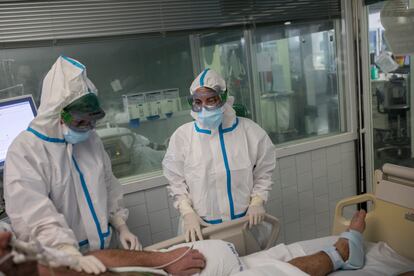 La doctora Zapatero y una compañera atienden a un paciente en la UCI covid.