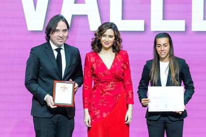 Isabel Díaz Ayuso (en el centro) ha entrega de la distinción al Rayo Vallecano, que recogen el entrenador del equipo masculino, Raúl Martín Presa, y la capitana del equipo femenino, Iris Ponciano.