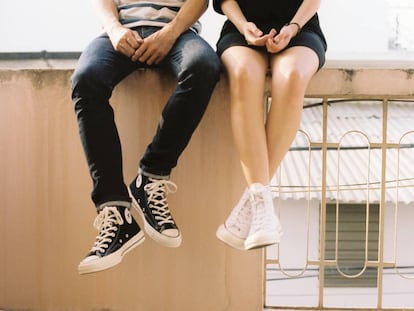 Dos adolescentes se sientan en una cornisa. 