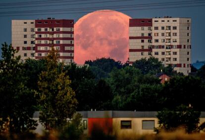 La luna llena se pone detrás de los edificios de apartamentos en las afueras de Frankfurt (Alemania) la madrugada del viernes. 