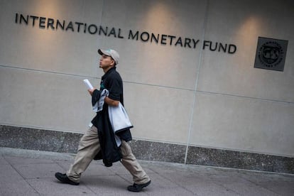 un hombre pasa ante la sede del FMI en Washington