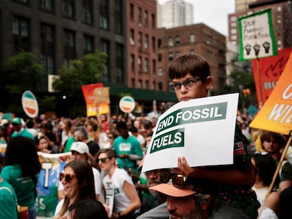 Oliver Moore, 7, of Montpelier, Vermont, listens to a speaker during a rally to end the use of fossil fuels, in New York, Sunday, Sept. 17, 2023.