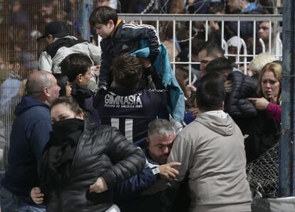 Aficionados son evacuados del campo en el estadio Juan Carmelo Zerillo, en la ciudad argentina de La Plata, 50 kilómetros al sur de la capital, Buenos Aires. Un hombre de 57 años ha muerto de un infarto mientras era trasladado al hospital, después de que la policía se enfrentara con los fanáticos de Gimnasia y Esgrima de La Plata a las puertas del estadio.