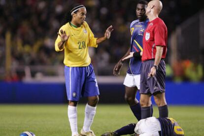 Ronaldinho se dirige al árbitro con un jugador ecuatoriano caído sobre el césped.