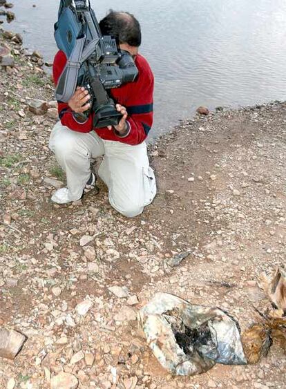 Un cámara enfoca el saco con huesos hallado en el embalse de Arade (Portugal).