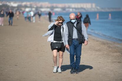 Una pareja pasea en la playa de la Malvarrosa, en Valencia.