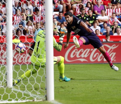 El delantero uruguayo del FC Barcelona Luis Suárez (d) frente al portero del Sporting de Gijón Iván Cuéllar (i).