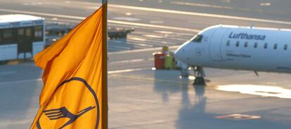 A plane by Lufthansa is seen next to a Lufthansa flag at the international airport in Munich